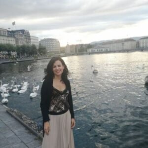 Mujer al atardecer en un lago con cisnes