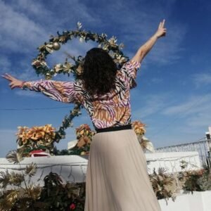 Mujer de espalda alzando brazos al cielo